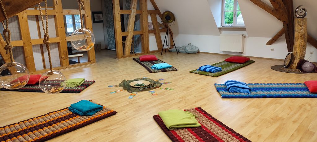 Liebevoll vorbereiteter Workshop-Raum in der ImpulsQuelle mit bunten Bodenmatten, Kissen und hängenden Glaskugeln, Symbolbild für die Workshops in Stein bei Nürnberg